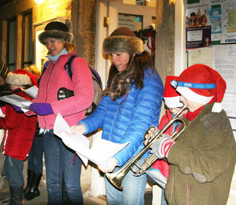 Carol singers tune up outside the community shop